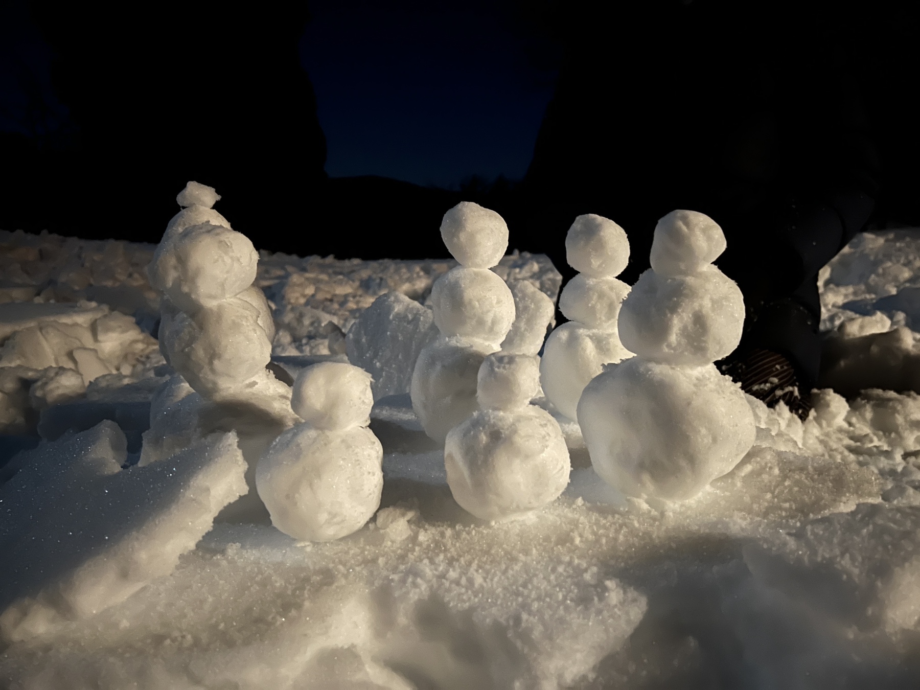 a cluster of seven small snow people gathered together