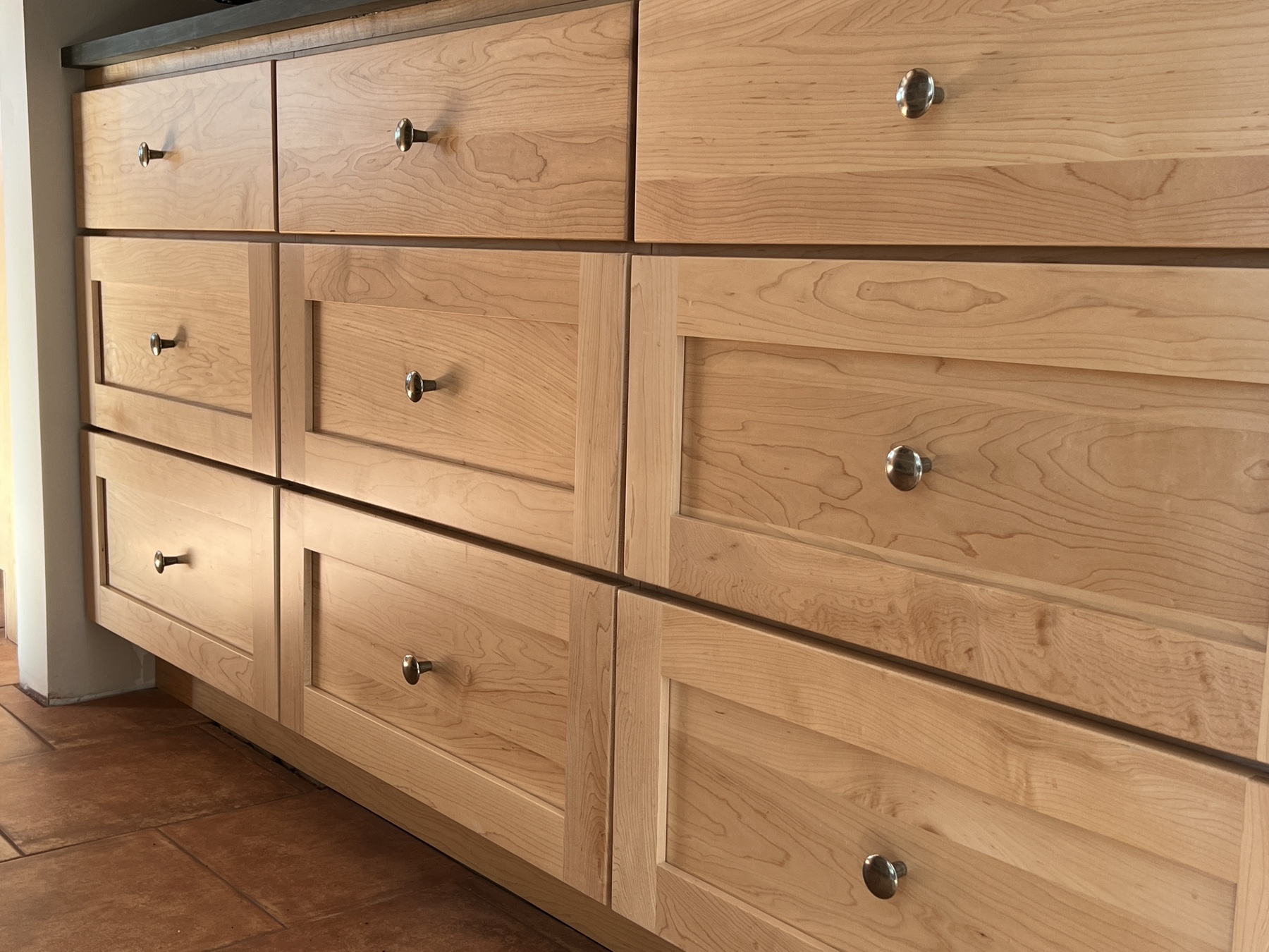 nine drawers in a pantry with shiny pewter knobs freshly installed
