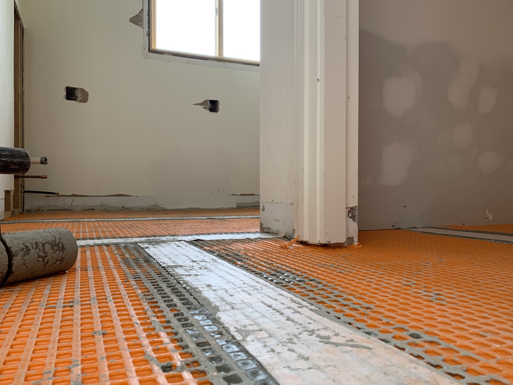 a subfloor with orange decoupling membrane used to support the tile shown in yesterday's photo